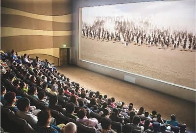 游客在莫高窟數字展示中心觀看主題電影《千年莫高》。 游客在莫高窟數字展示中心觀看主題電影《千年莫高》。