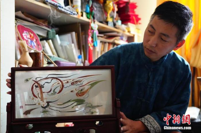 圖為劉云帆展示敦煌元素的刺繡作品。 中新社發 謝秉錫 攝 圖為劉云帆展示敦煌元素的刺繡作品。 中新社發 謝秉錫 攝